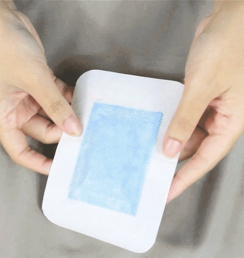 Two hands holding an adhesive detox foot pad, an image from a different product line